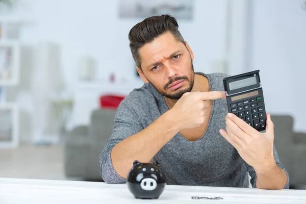 Uomo Con Salvadanaio Guardando Tristemente Calcolatrice — Foto Stock