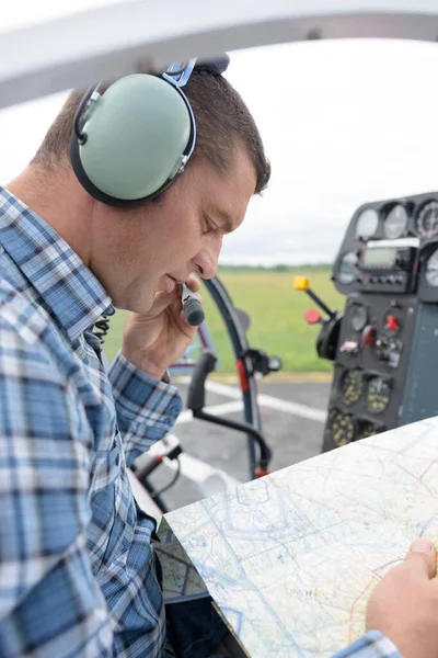 Mężczyzna Pilot Patrzy Mapę Mówi Mikrofonu Słuchawkowego — Zdjęcie stockowe