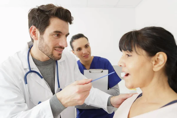 Médico Comprobando Boca Del Paciente Femenino Maduro —  Fotos de Stock