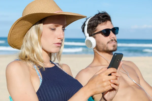 Couple Utilisant Leur Téléphone Sur Plage — Photo