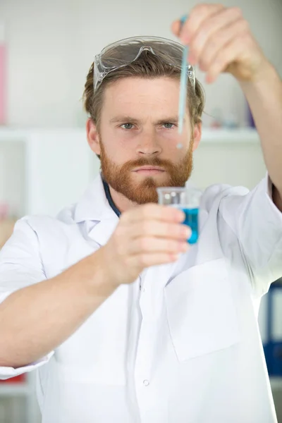Αρσενικός Επιστήμονας Ρίχνει Υγρό Ένα Ποτήρι Ζέσεως — Φωτογραφία Αρχείου