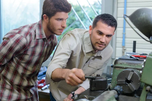 Engineer Adjusting Machinery Apprentice Watching Him —  Fotos de Stock