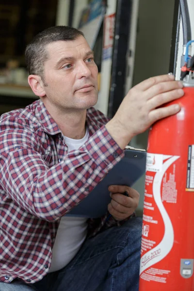 Technician Checking Red Fire Extinguisher —  Fotos de Stock