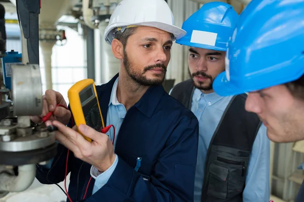 Three Engineers Reading Voltage Generator —  Fotos de Stock