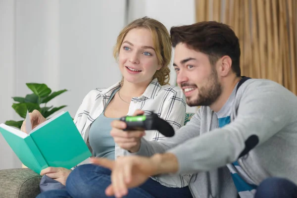 Freund Spielt Videospiele Und Freundin Liest Buch — Stockfoto