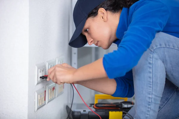 女性電気技師が壁に電力点ソケットを設置し — ストック写真