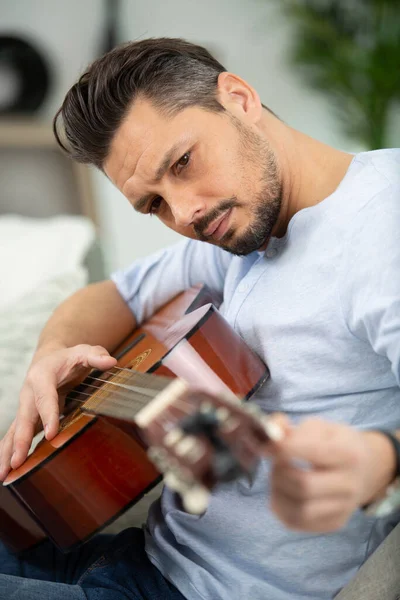 Sério Músico Masculino Afinando Sua Guitarra — Fotografia de Stock