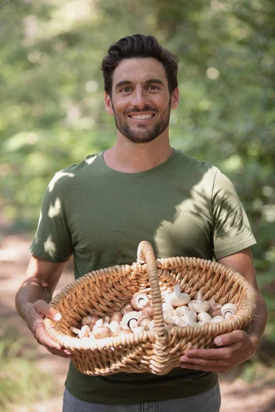 Jovem Sorridente Homem Mantém Mãos Pilha Cogumelos Frescos Orgânicos — Fotografia de Stock