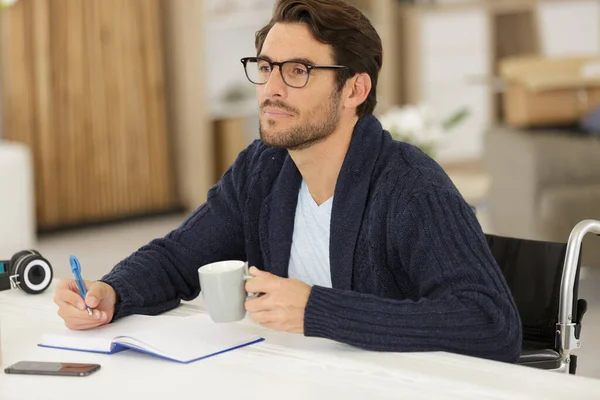 Man Med Funktionshinder Satt Vid Ett Bord Och Skrev Bok — Stockfoto