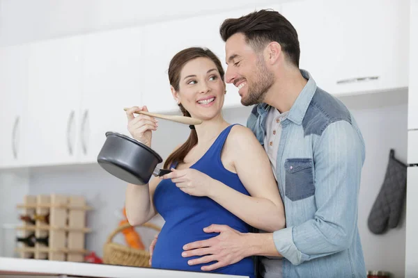 Hombre Tratando Sus Embarazadas Esposas Salsa Cocina —  Fotos de Stock