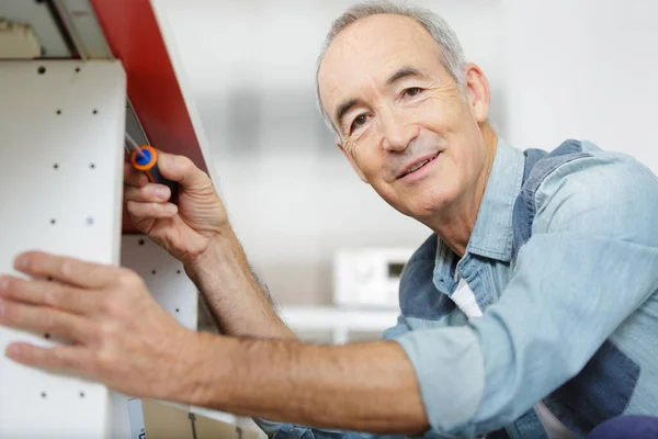 Senior Handyman Assembling Kitchen Cupboard — Stock Photo, Image