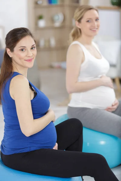 坐在健身球上笑着的孕妇 — 图库照片