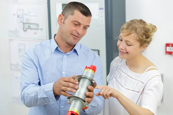 Sicherheitsbeauftragter Zeigt Frau Zylinderteil — Stockfoto