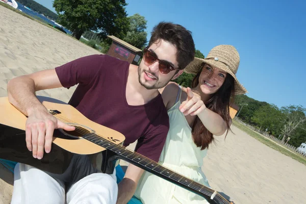 Gitarı Kız Arkadaşı Sahilde Olan Genç Bir Adam — Stok fotoğraf