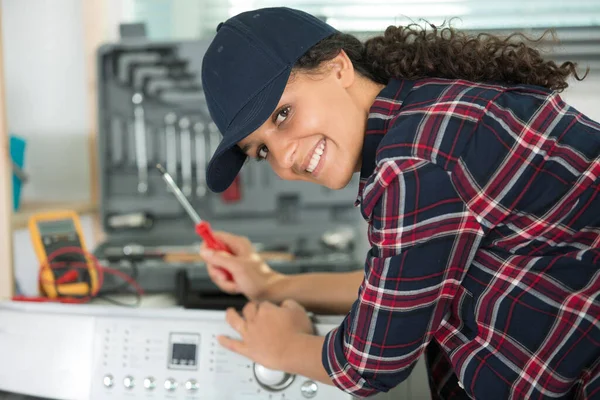 快乐的女学徒工程师在洗衣机上工作 — 图库照片