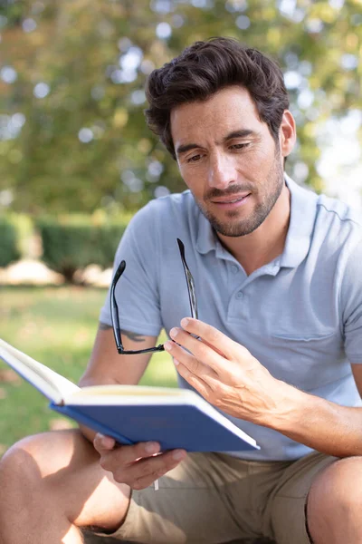 Hombre Leyendo Libro Aire Libre Sosteniendo Gafas — Foto de Stock