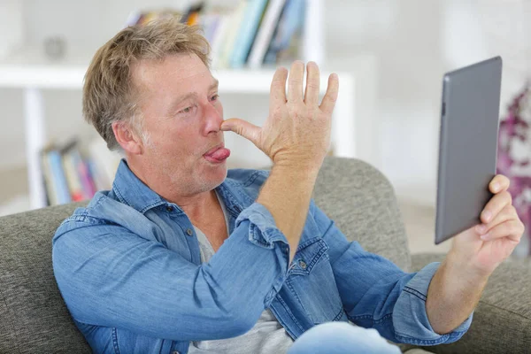 Zralé Pohledný Muž Legrační Tváří Tabletu — Stock fotografie