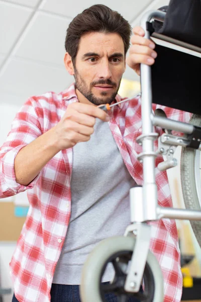 Young Man Repairing Broken Wheelchair Part — Stock Photo, Image