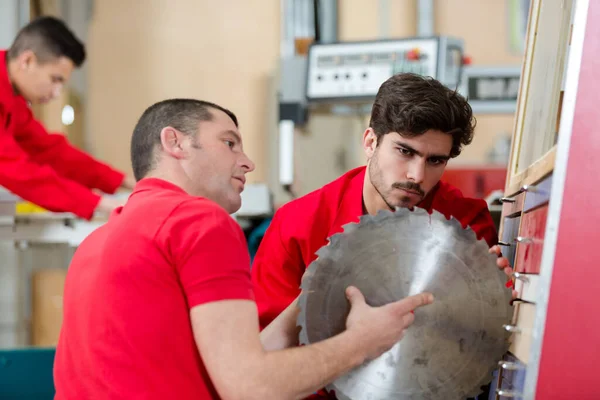 Due Lavoratori Che Ispezionano Lama Frastagliata — Foto Stock