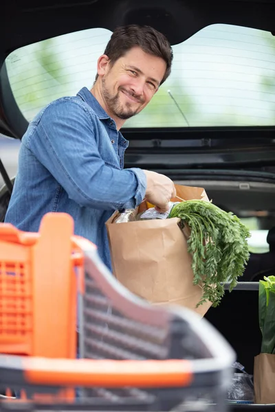 Stilig Man Packning Matvaror Bilen Bagageutrymmet Utomhus — Stockfoto