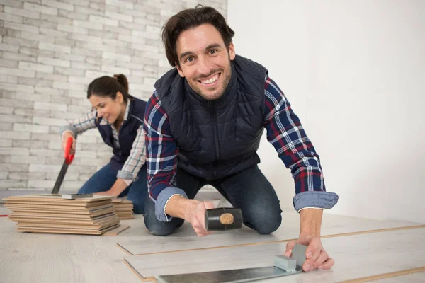 Couple Pose Nouveau Plancher Bois — Photo