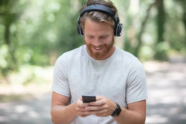 Glücklicher Mann Der Medieninhalte Auf Einem Smartphone Verfolgt — Stockfoto