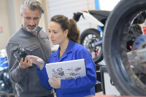 Pozytywny Mężczyzna Jest Wspomagany Przez Kobiety Mechanika Motocykl — Zdjęcie stockowe