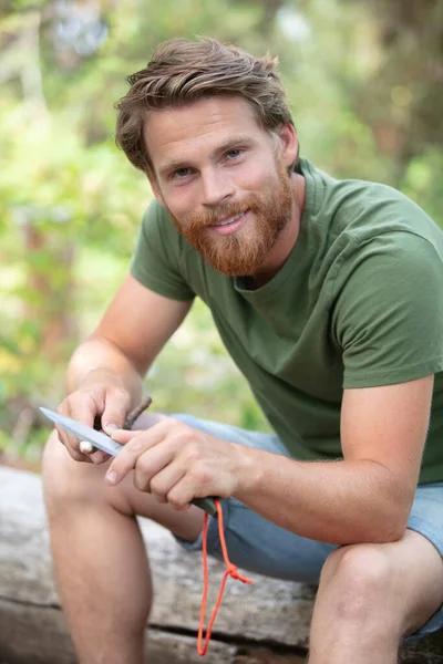 Uomo Affilare Bastone Legno Con Coltello Nel Bosco — Foto Stock