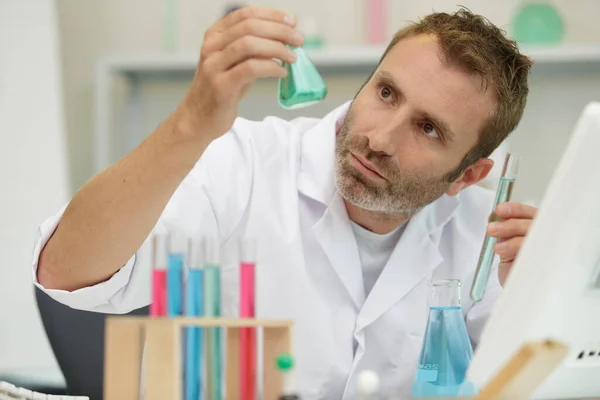 Scientist Holding Small Erlenmeyer Flask Light Stock Photo