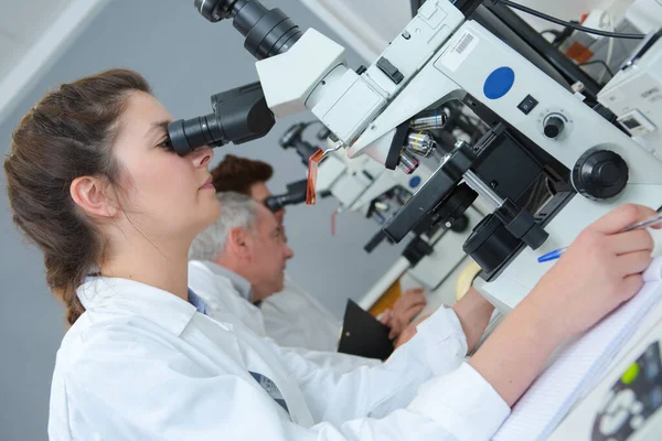 Vrouw Inspecteert Een Organisme Door Microscoop — Stockfoto