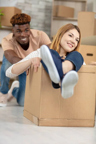 Man Pushing Woman Floor Cardboard Box — Stock Photo, Image