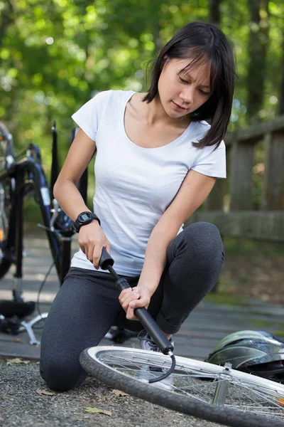 Kadın Bisikletinin Lastiğini Şişiriyor — Stok fotoğraf
