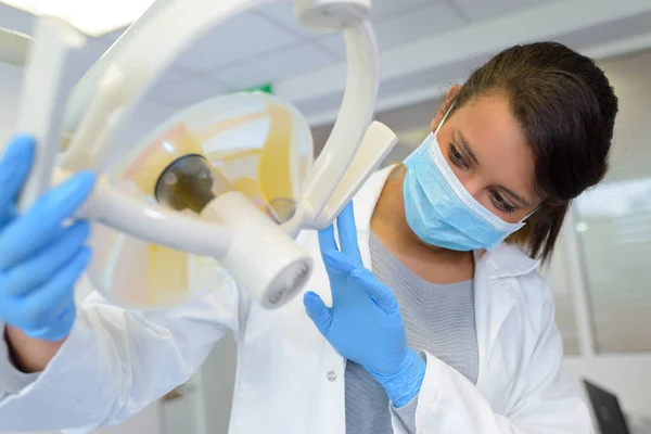 Dentista Femenino Ajustando Luz Eléctrica Clínica Odontología —  Fotos de Stock