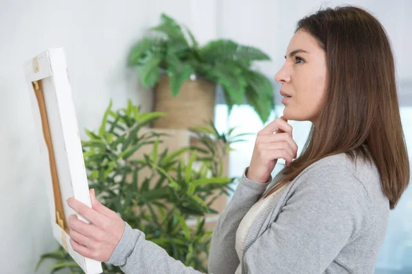 Vrouw Overweegt Waar Een Kunstdoek Hangen — Stockfoto