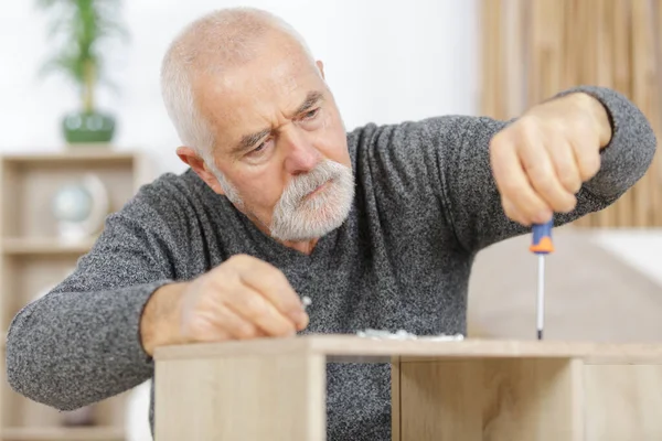 Mogen Man Skruvar Möbel — Stockfoto