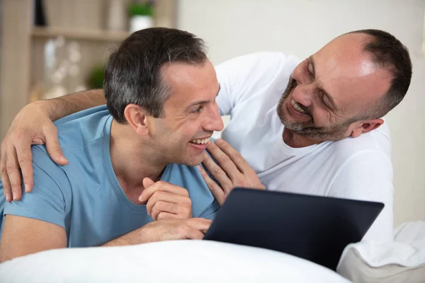 Mann Umarmt Einen Freund Während Ein Tablet Der Hand Hält — Stockfoto