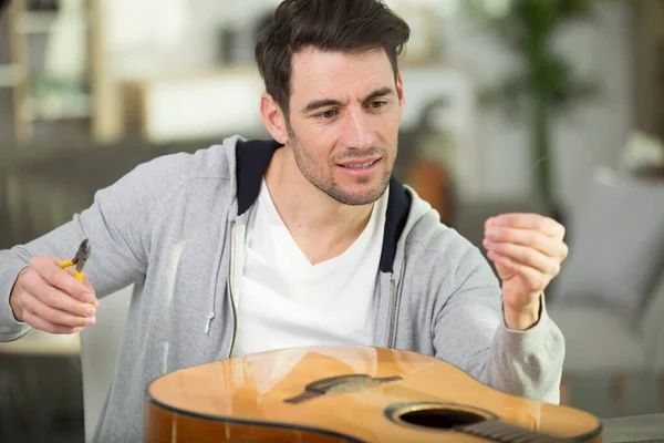 Jovem Homem Mudando Cordas Guitarra — Fotografia de Stock