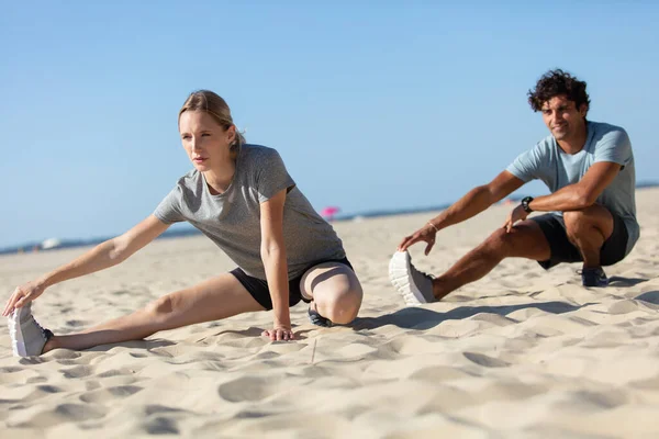 Ungt Par Man Och Kvinna Stretching Ocean Beach — Stockfoto