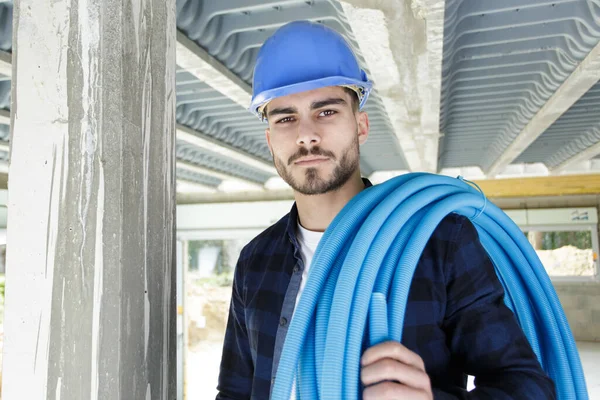 Constructeur Masculin Avec Bobine Tuyau Bleu Sur Son Épaule — Photo