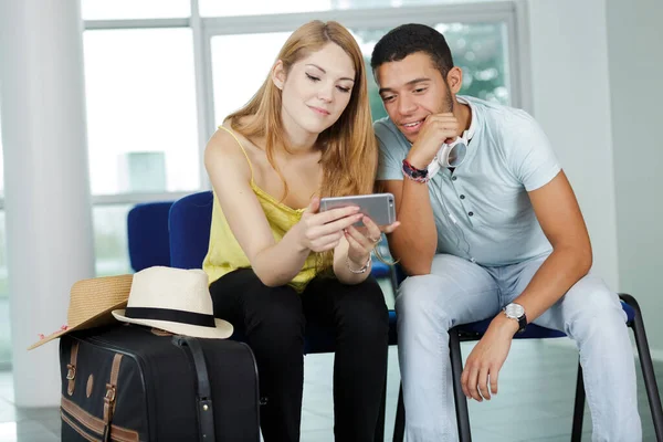 Młoda Para Korzystająca Internetu Przez Telefon Komórkowy Lotnisku — Zdjęcie stockowe