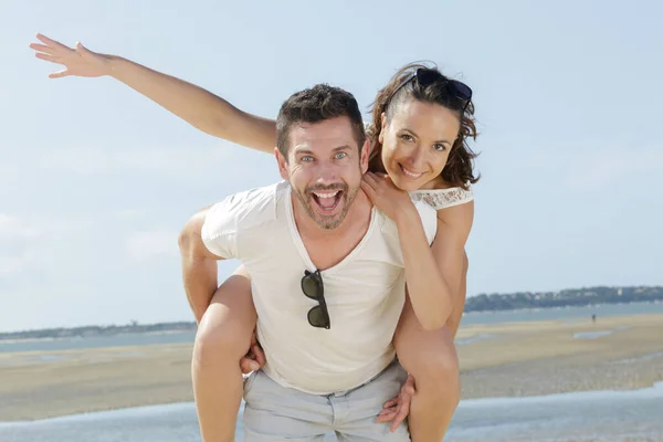 Piggybacks Pareja Playa —  Fotos de Stock