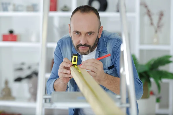 Man Measuring Wooden Board Home — Stock Photo, Image