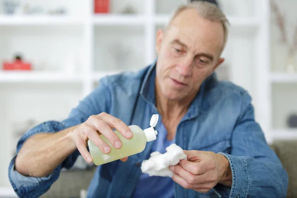 Senior Hält Alkohol Und Baumwolle — Stockfoto