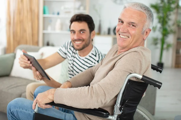 Gelukkig Vader Rolstoel Zoon Met Behulp Van Tablet — Stockfoto