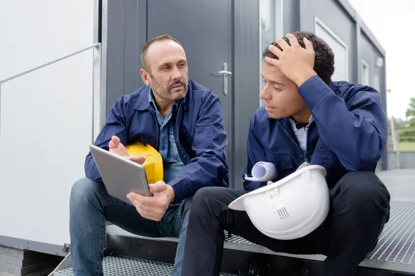 Dos Trabajadores Masculinos Cuello Azul Descanso Mirando Tableta —  Fotos de Stock