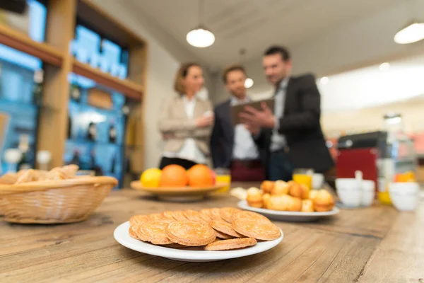 Snacks Table Foreground Businesspeople Tablet Background — Stock Photo, Image