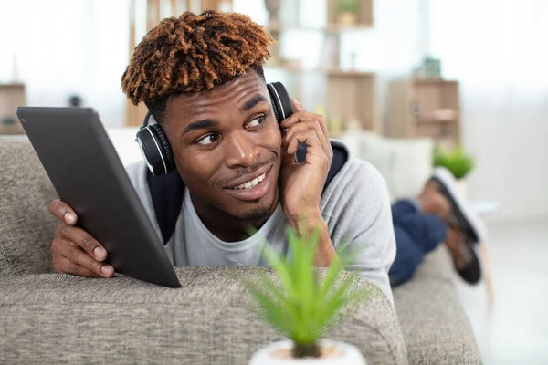 Mann Auf Sofa Mit Digitalem Tablet Und Kopfhörer — Stockfoto