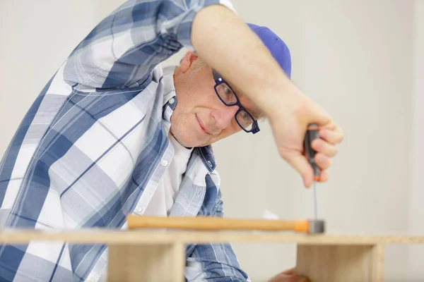 Älterer Mann Schraubt Einen Holztisch — Stockfoto
