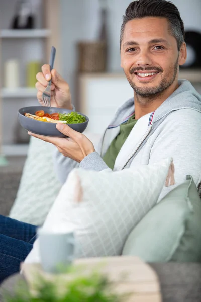 Glad Kille Sitter Soffan Och Äter Sallad — Stockfoto