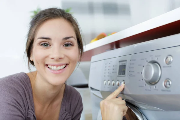 妇女在洗衣机上按下按钮的近视 — 图库照片